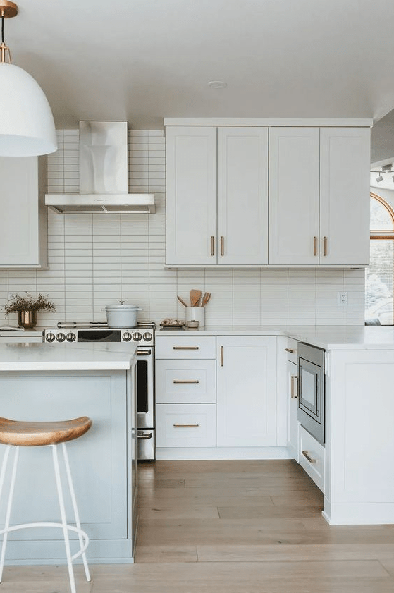 a serene white kitchen with stacked tile backsplash, shaker cabinets, white countertops and wooden stools