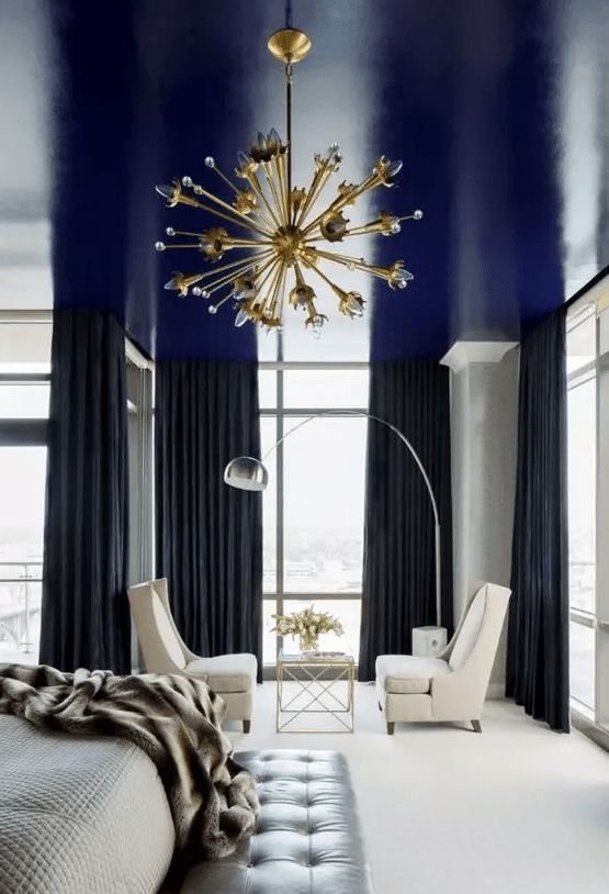 A glossy navy blanket is a cool way to add a pop of color and moody vibe to the monochromatic bedroom