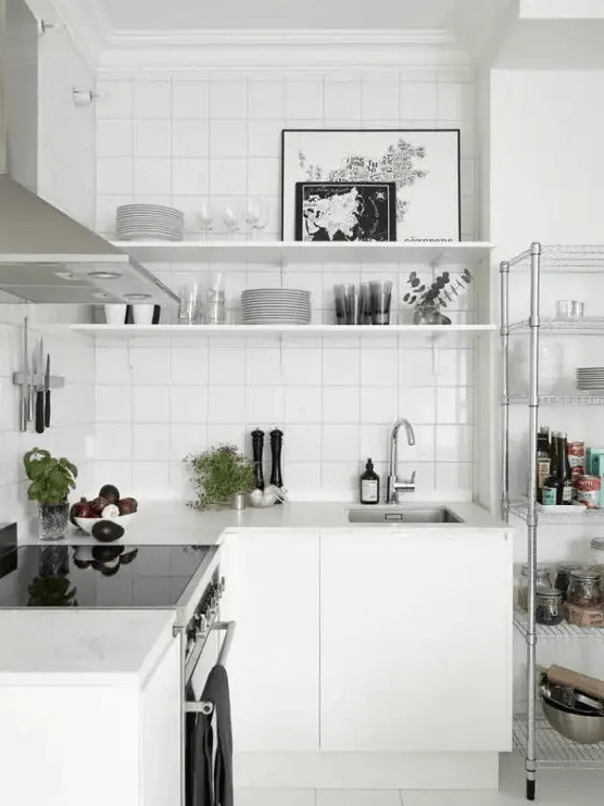 A white Nordic kitchen with a white tile backsplash and stainless steel appliances is a very airy space