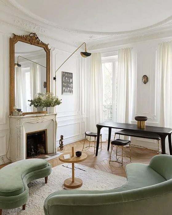 an elegant living room with a marble-clad fireplace, a green curved sofa and bench, a side table, a black table and stools