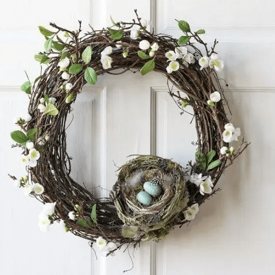 A vine spring wreath with artificial flowers and leaves, a nest with feathers and eggs is a cool decoration that you can easily make yourself