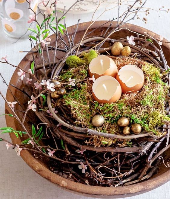 A beautiful Easter centerpiece made from a vine nest, moss, eggshell candles and golden eggs and artificial flowers is fantastic