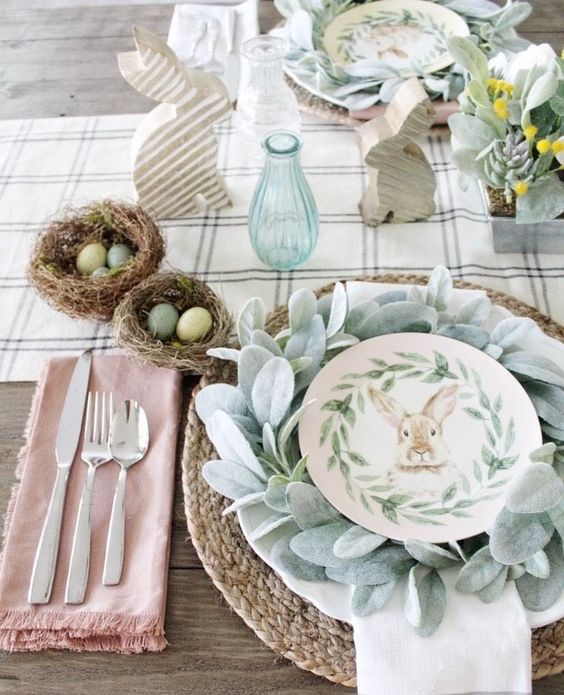 a neutral, farmhouse-style tablescape with printed textiles, a woven placemat, faux greenery and succulents, and nests of eggs as decoration