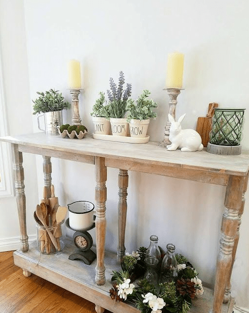 a rustic Easter console table with potted plants and flowers, moss, candles and a porcelain bunny