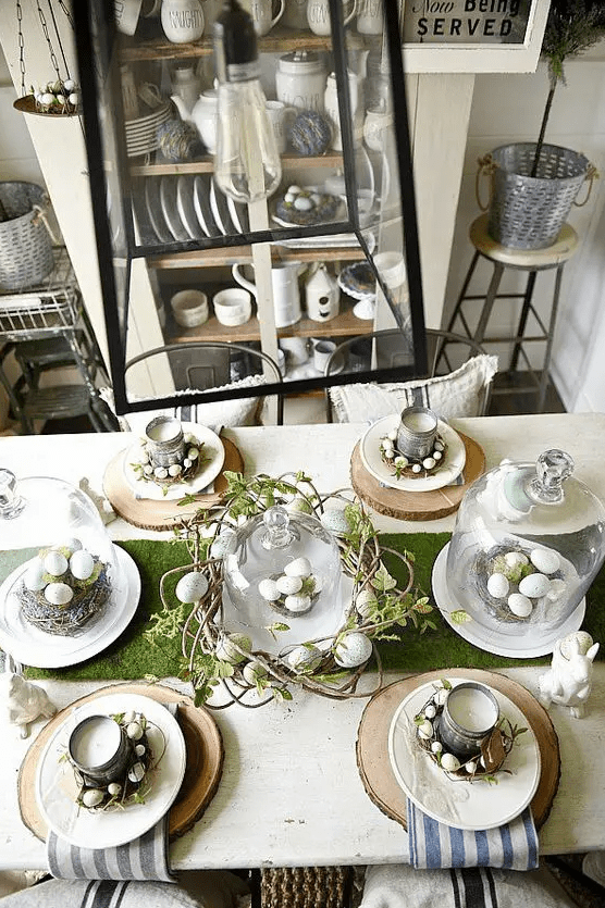 a rustic Easter table with wooden slices, striped napkins, candles made from tin cans and vine wreaths with eggs