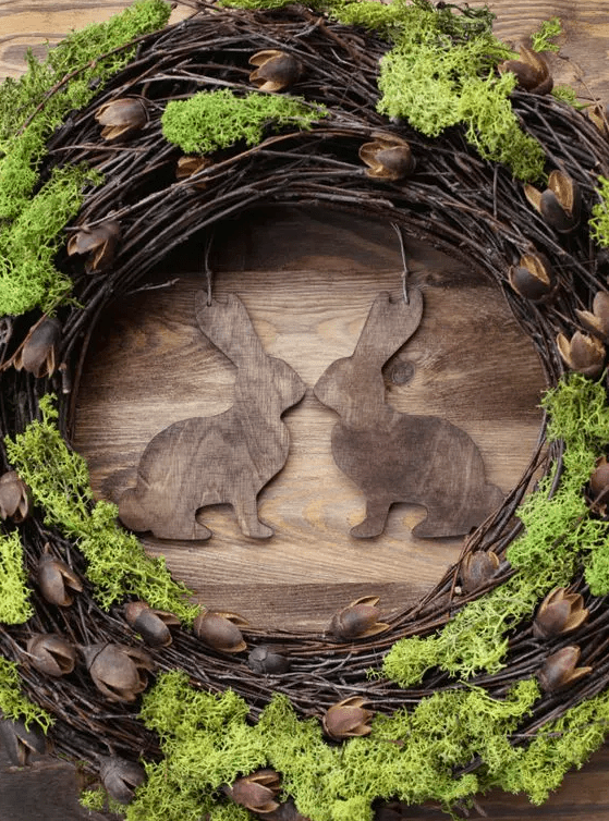 A rustic grapevine wreath with wooden bunnies and moss is a cool and eye-catching decoration for a rustic space